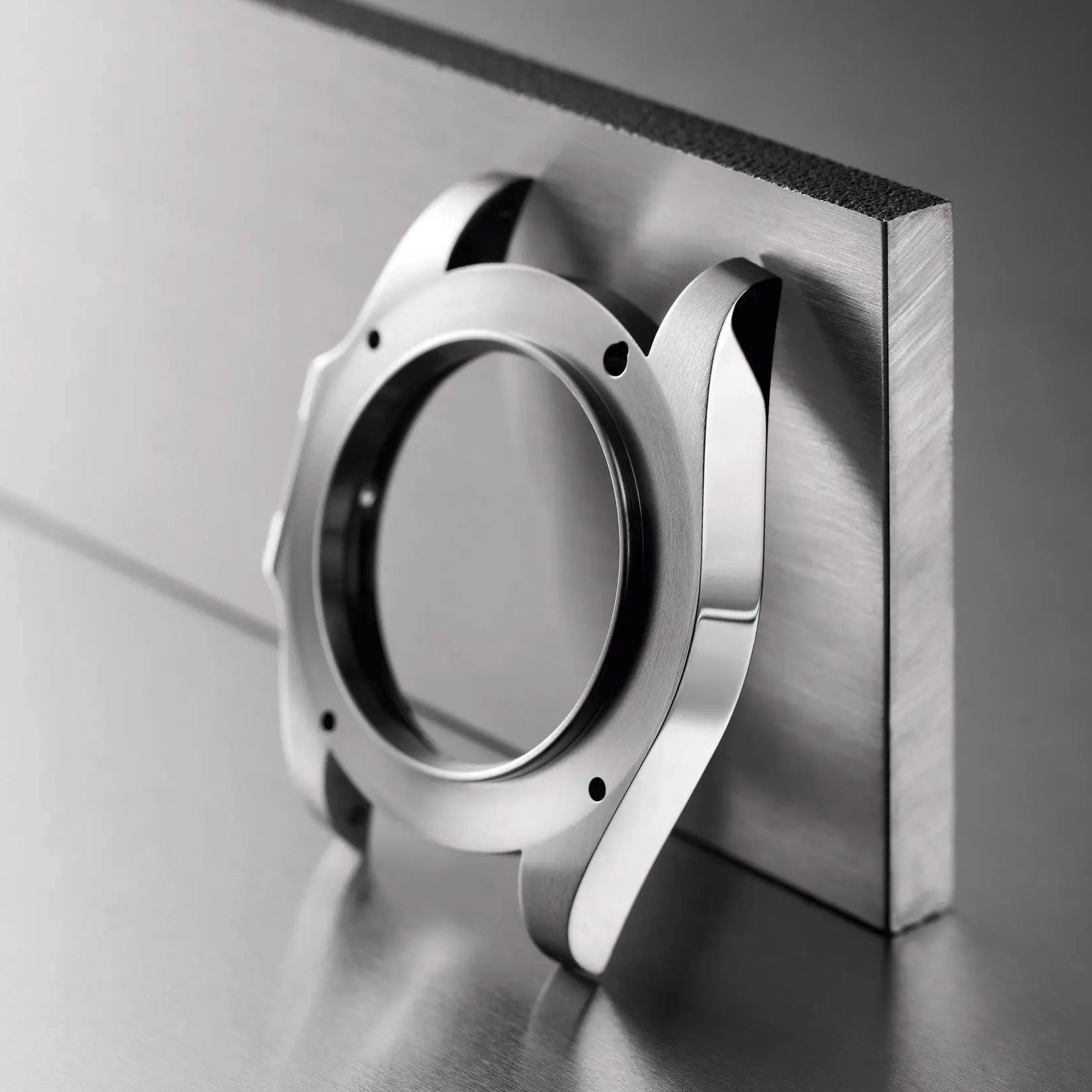 Boîtier de montre SeikoMod en acier inoxydable 316L, posé sur un bloc d'acier brut, design moderne et robuste