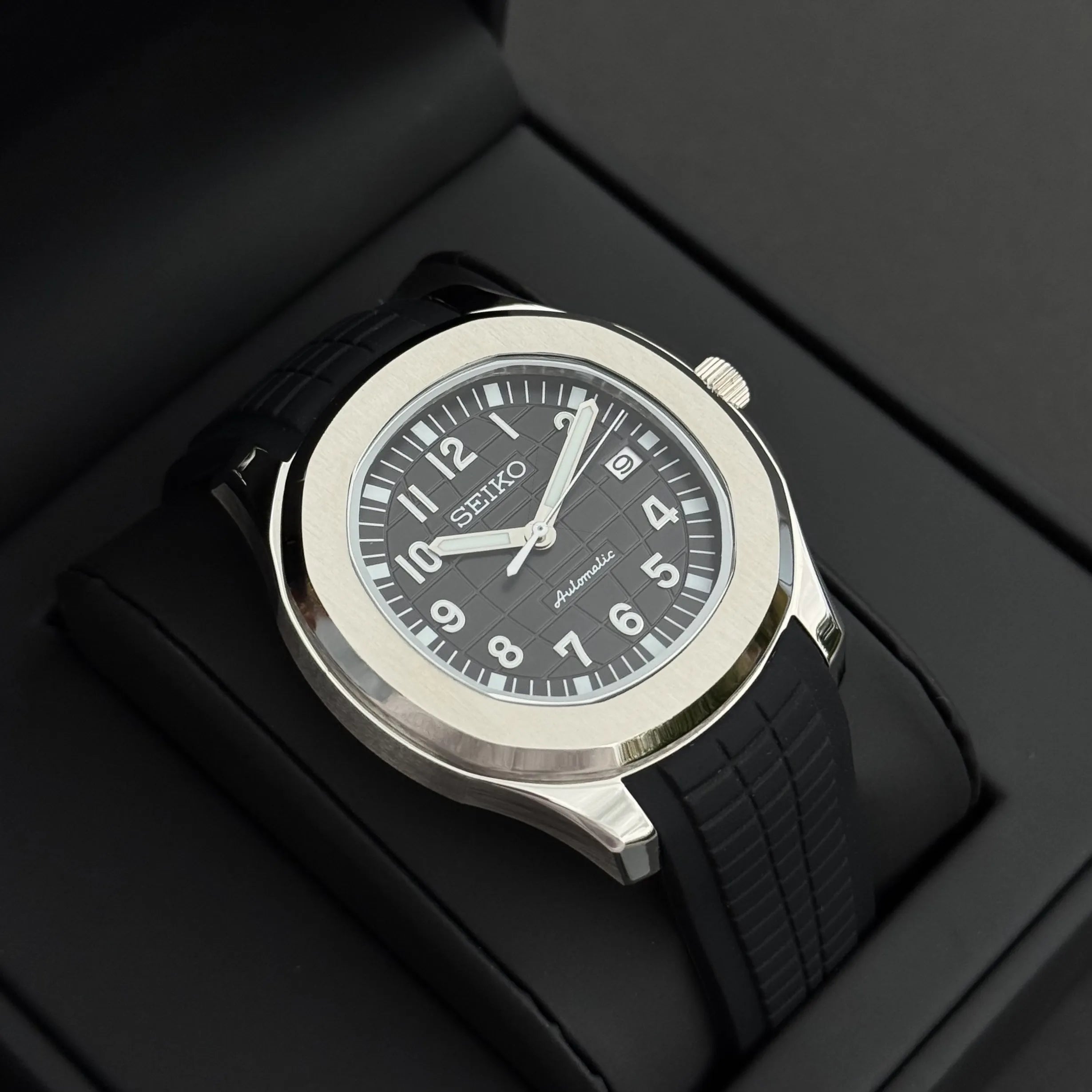 Montre Seiko Mod Aquanaut noire avec cadran texturé et boîtier acier inoxydable 40mm posée dans son écrin