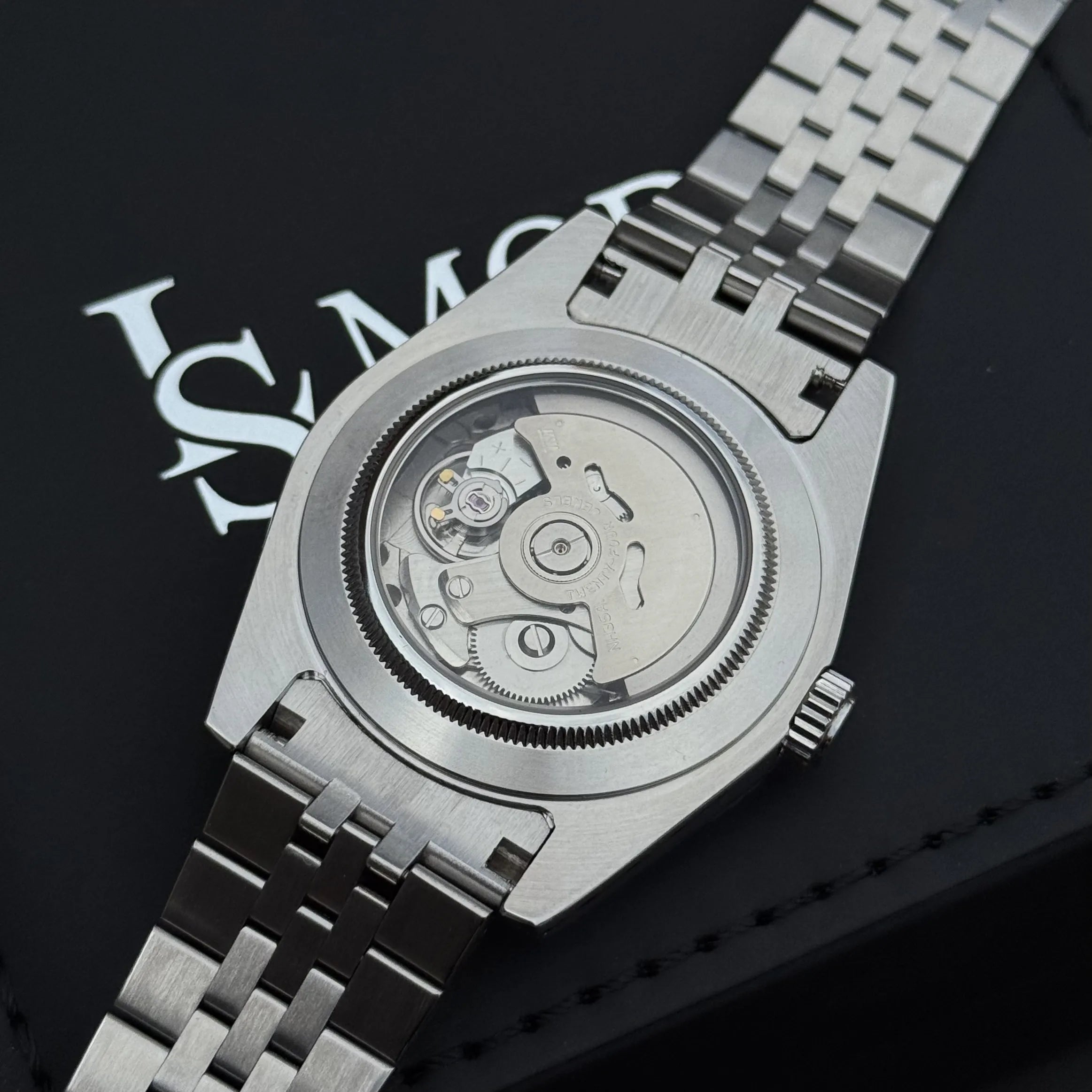 Mouvement automatique Seiko NH35 visible à travers le fond transparent en verre saphir inrayable du boîtier datejust