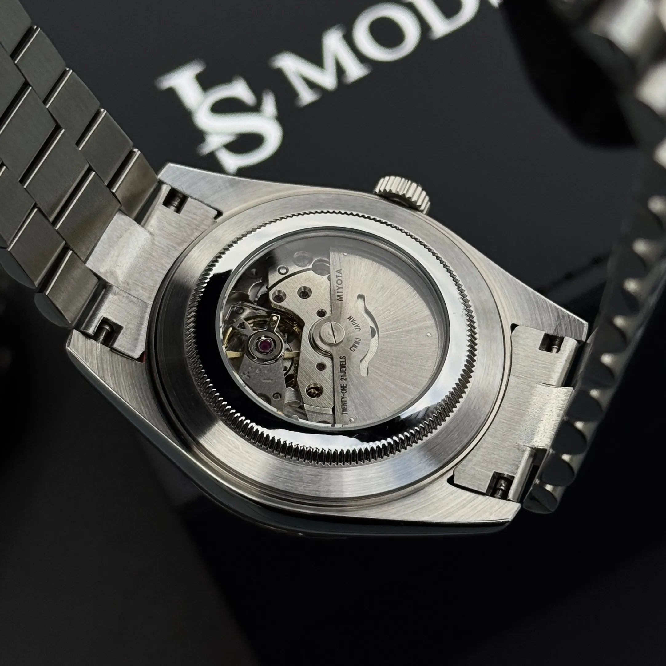 Montre Seiko Mod Day-Date mouvement automatique Miyota 8285 visible à travers le fond de boitier transparent en verre saphir