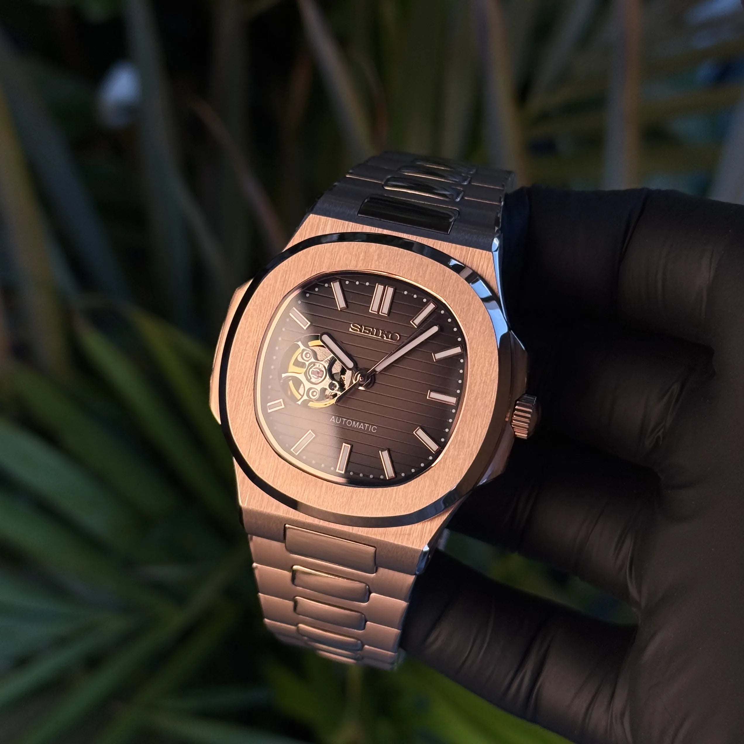 Montre SeikoMod Nautilus Skeleton Or Rose Chocolate mouvement automatique NH38 présentée en action, cadran marron et boîtier or rose